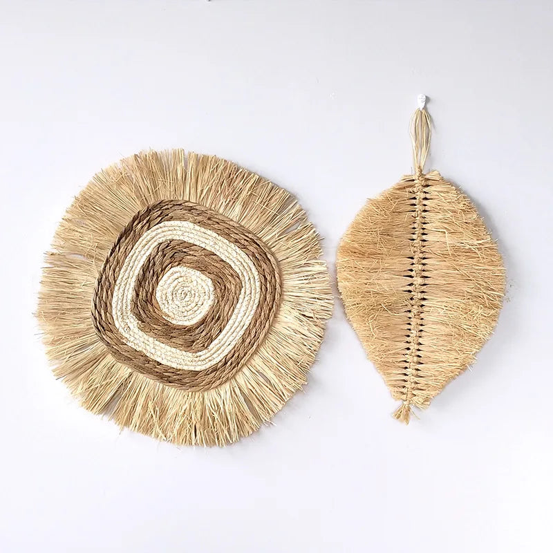 Round raffia wall hanging and leaf-shaped raffia wall decor side by side on a wall