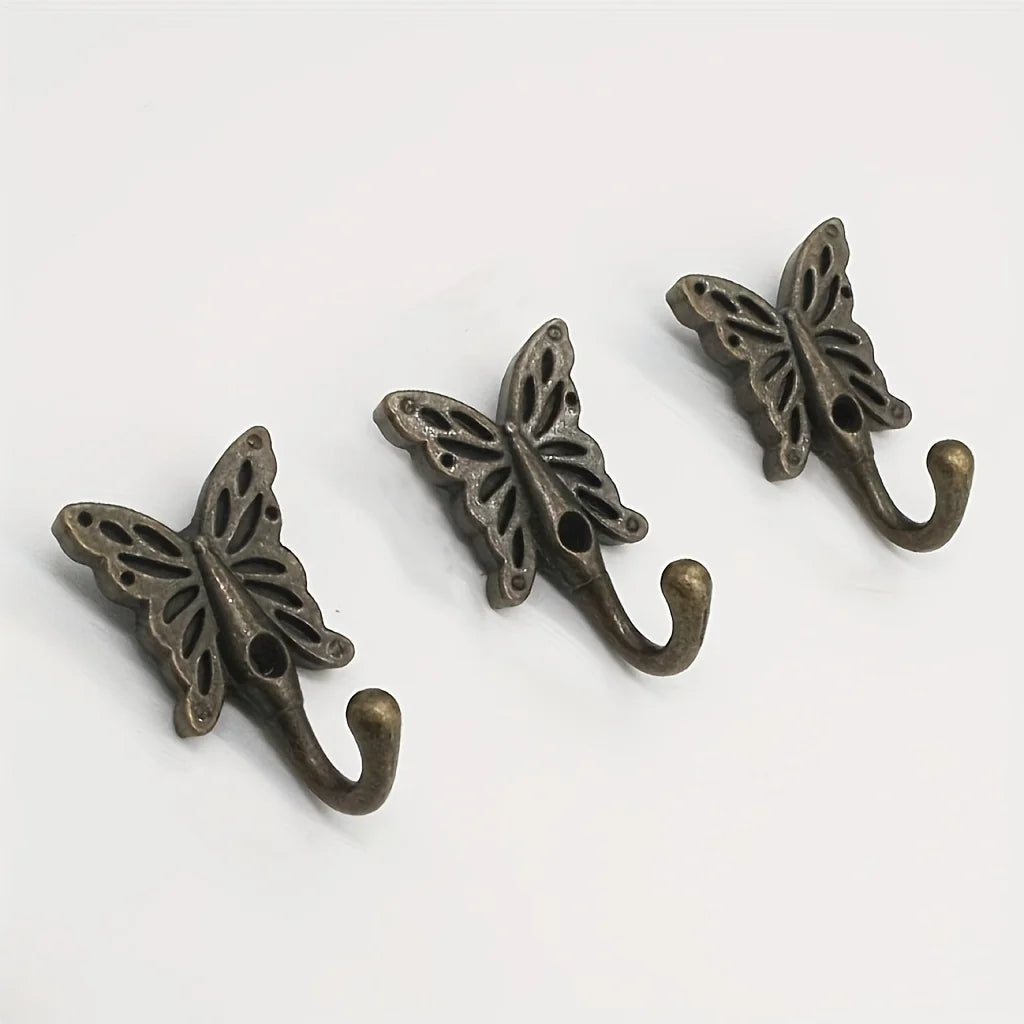 Three butterfly cast iron wall hooks displayed on a white background