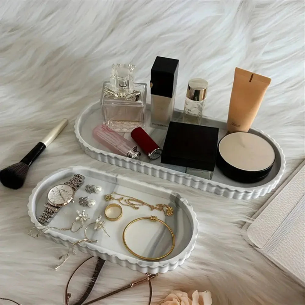 Ridged oval silicone trays in marble pattern shown with jewelry and cosmetics on a vanity