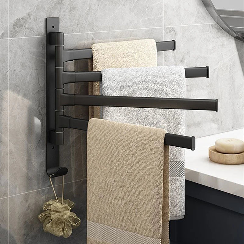 Black rotating wall-mounted towel rack holding three towels in a bathroom