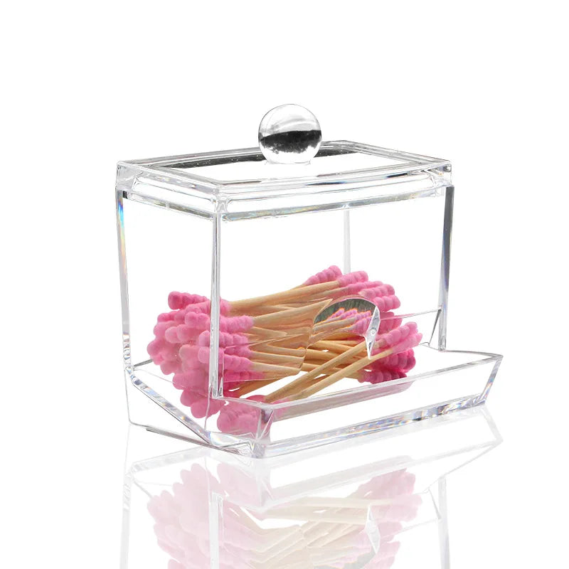 Clear cotton swab holder with clear lid containing pink cotton swabs on white background