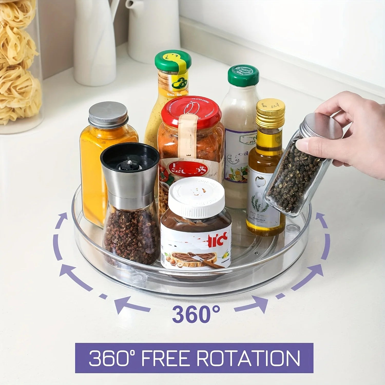 hand rotating a clear lazy susan filled with bottles and spice containers on a kitchen counter