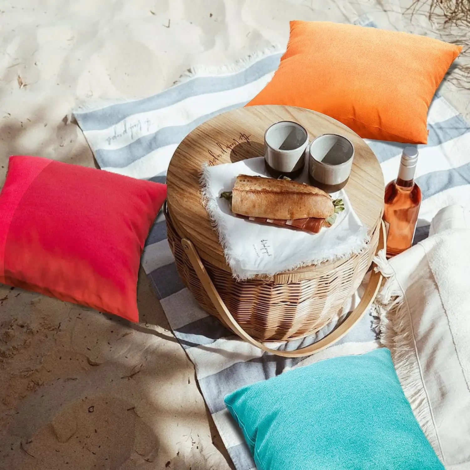 Bright waterproof cushion covers used as seating for an outdoor picnic on sand