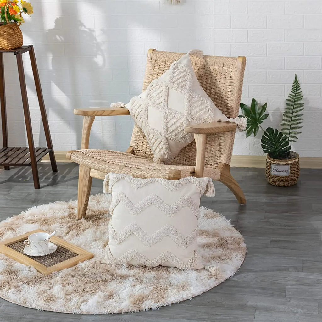 Tufted cotton pillow covers with tassel corners on a woven chair and fluffy rug in a living room