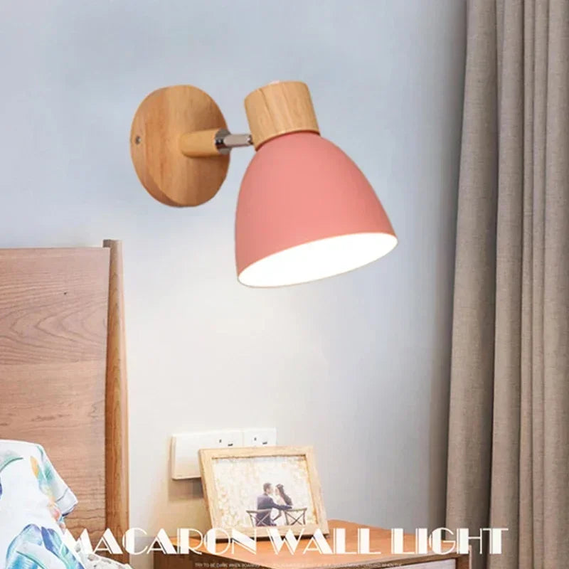 pink and wood wall sconce above a bedside table in a bedroom