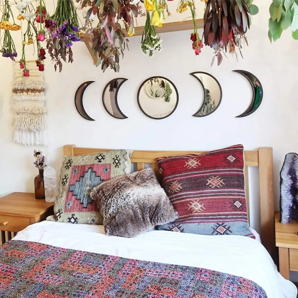 Boho bedroom with moon phase mirror set above headboard and dried floral decor