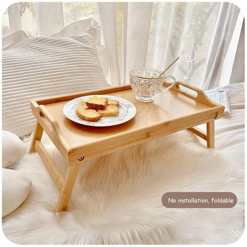 foldable bamboo bed tray table with cookies and tea on top of a bed