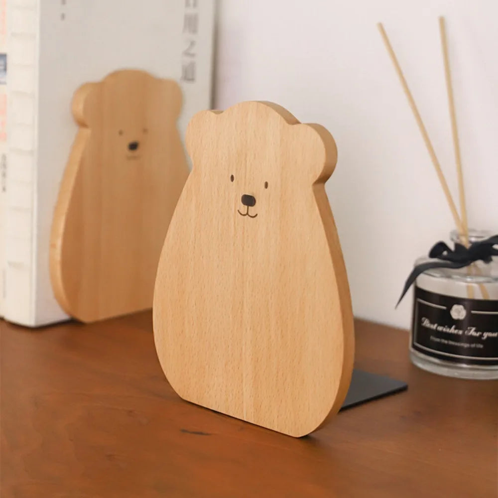 Angled view of light brown bear shape wooden bookend on a wooden surface