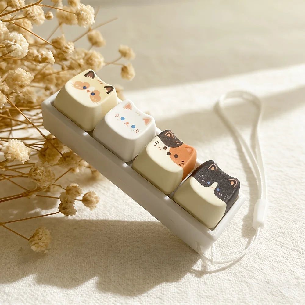 Cat key lanyard placed near dried flowers on a soft surface, highlighting the whimsical cat faces
