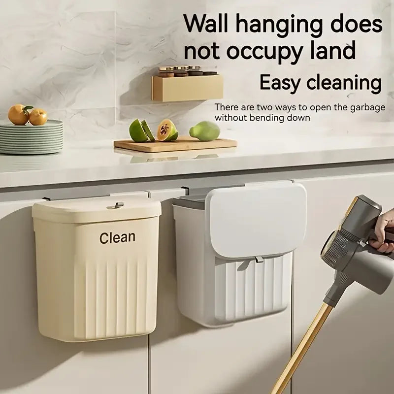Beige and white wall-mounted trash bins with lids hanging on kitchen cabinet doors in a modern kitchen setting