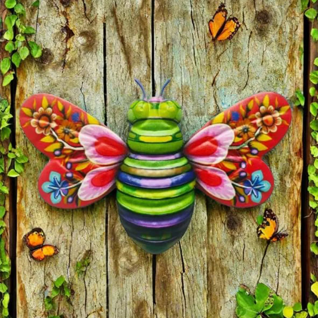 Red and green 3D bee metal wall sculpture on rustic wood fence with butterflies