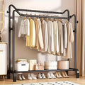 Black twin bar clothes rack with two hanging rails and a shoe shelf organized with clothes, bags, and shoes in a bedroom setting
