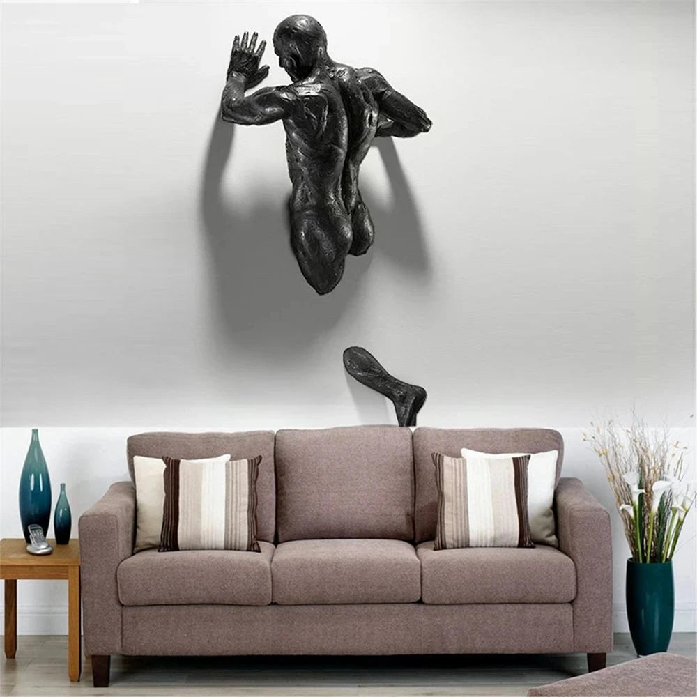 Climbing man wall sculpture displayed above a sofa in a living room for dramatic flair