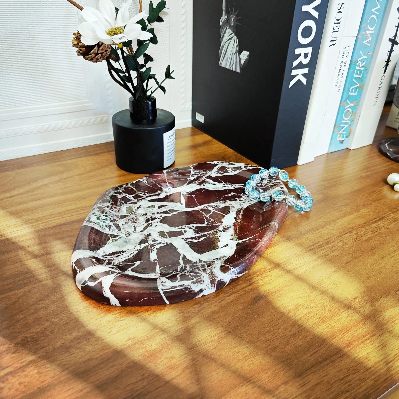 Purple ceramic stone-effect tray on wood surface with jewelry