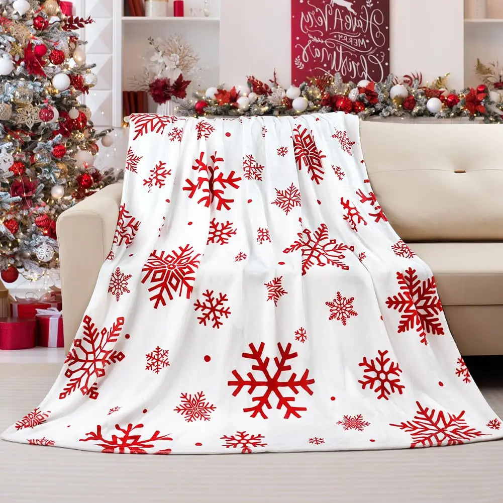 Red snowflake flannel throw blanket draped over a cream sofa in a festive living room