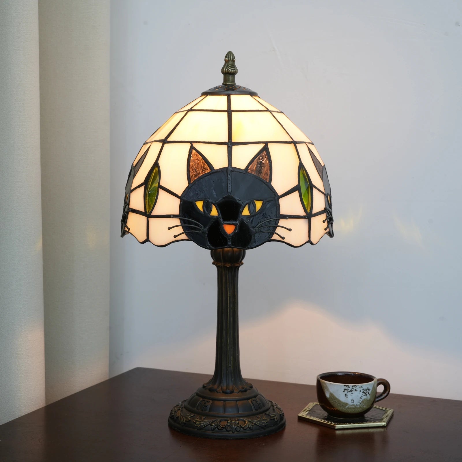 stained glass cat table lamp with lit shade on nightstand
