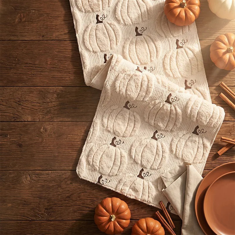 Close-up detail of beige pumpkin knit runner with autumn decor accents
