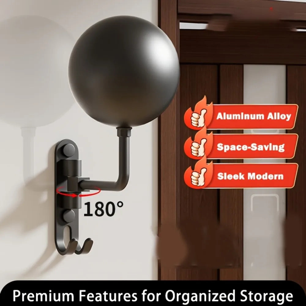 Close-up of black wall-mounted rotating helmet holder showing 180° adjustable arm and hooks, mounted near a door