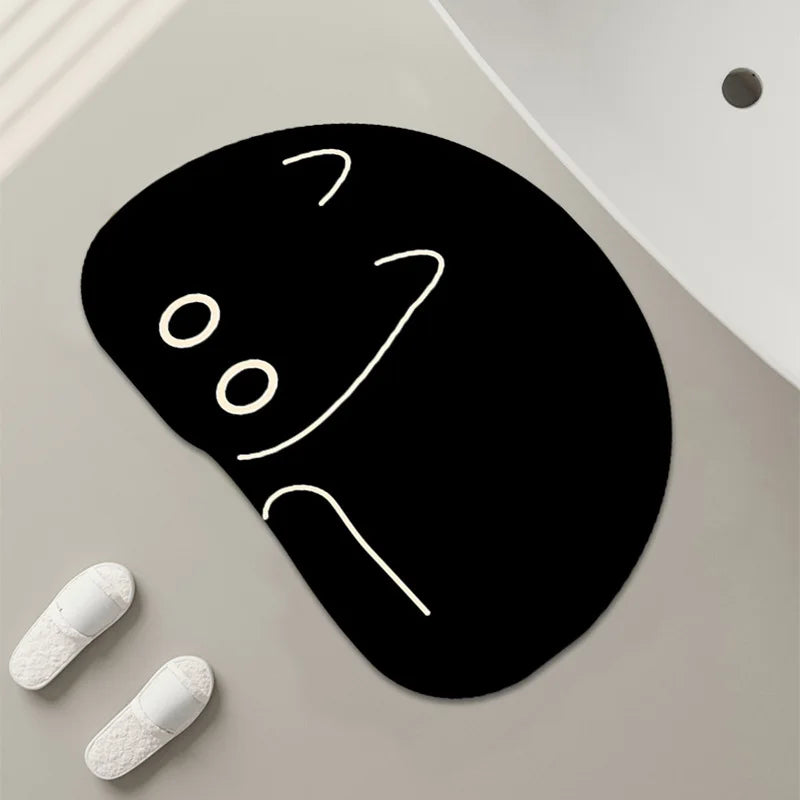 Rounded black cat bath mat with minimal line-drawn details, shown by a white sink.