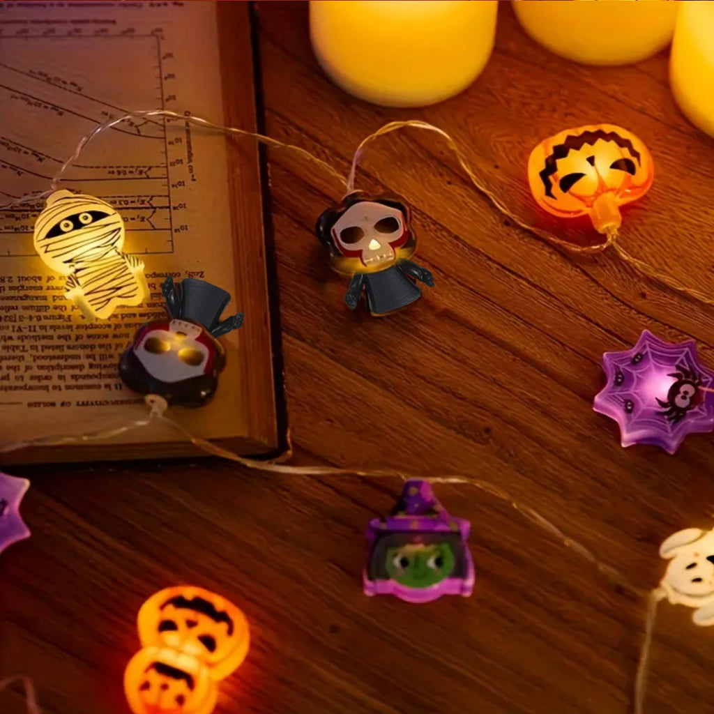 Close view of Halloween LED string lights with ghost, pumpkin, skeleton, and witch figures glowing around a book