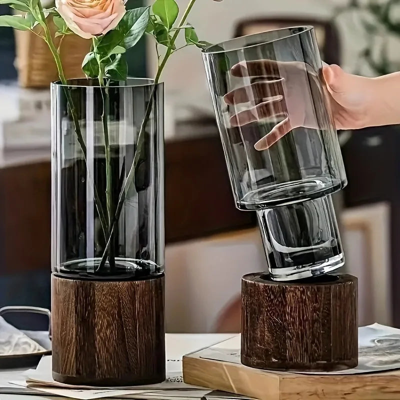 Hand lifting smoked glass cylinder from wooden base, showing removable design