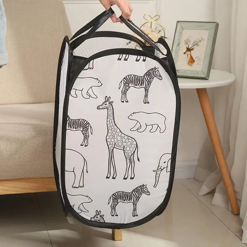 Collapsible mesh laundry hamper with black zebra, giraffe, and animal print, shown being carried in a cozy room.