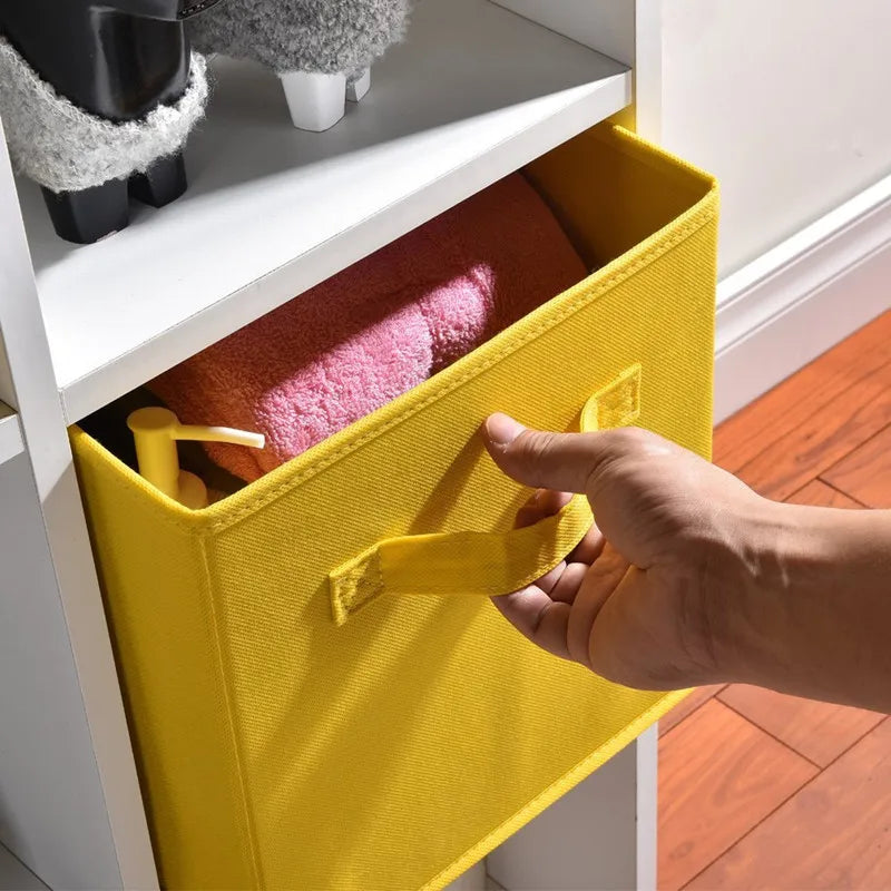 Hand pulling a yellow fabric cube storage bin out of a white shelf