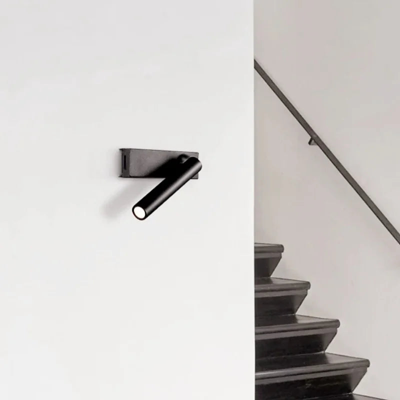 Modern black wall-mounted reading lamp with rotating spotlight installed in a stairway area
