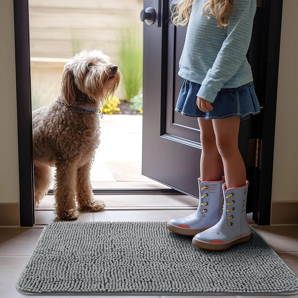 Child with boots and dog standing on grey absorbent doormat near open door