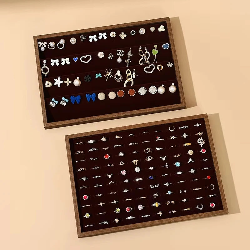 Wooden trays organizing earrings and rings, each with divided sections to keep pieces sorted