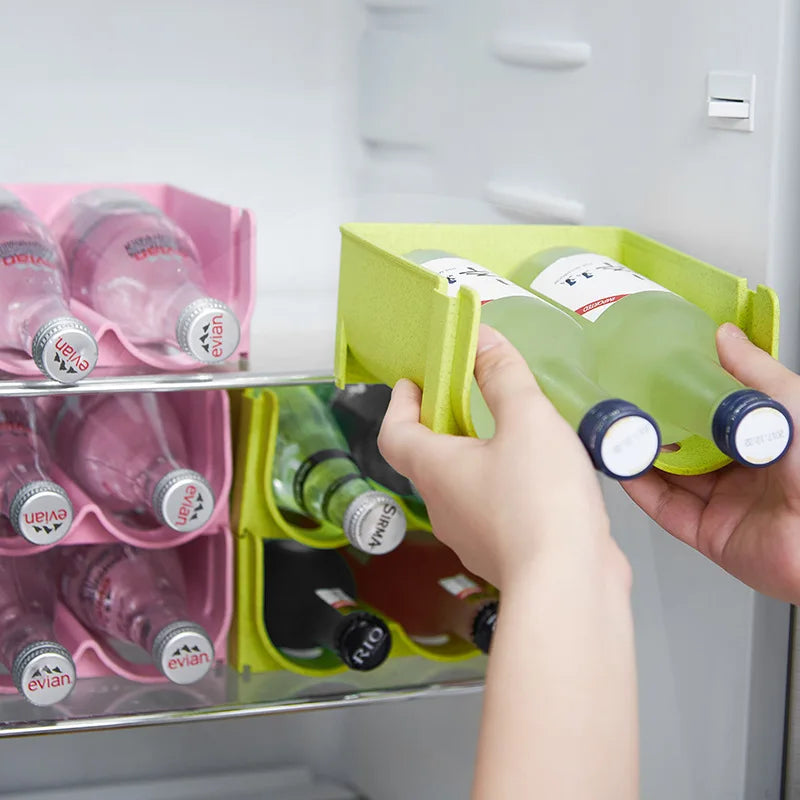 hands placing green stackable bottle organizer into a refrigerator with bottles