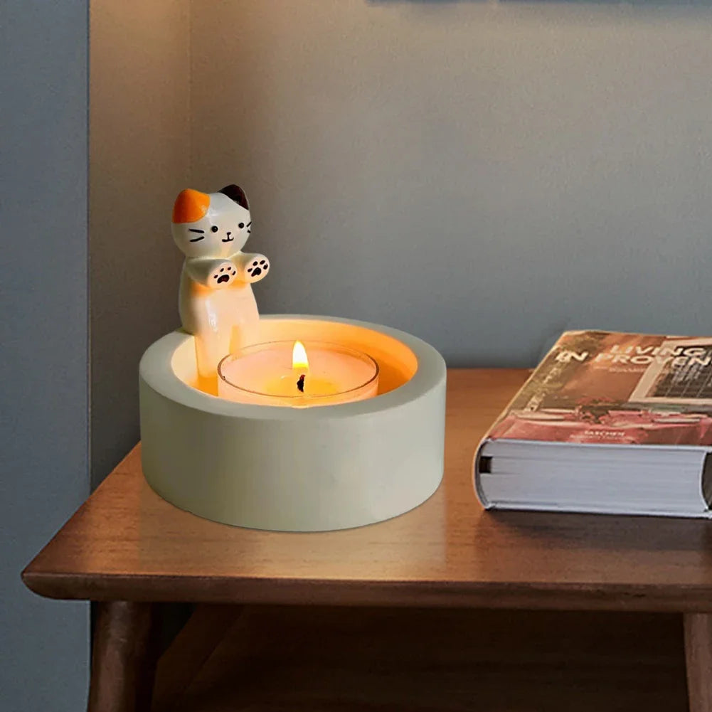 cat tealight candle holder placed on a bedside table next to a book