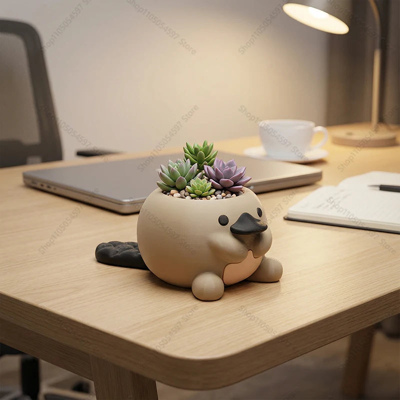 cute platypus desk planter with succulents on an office workspace with lamp and laptop