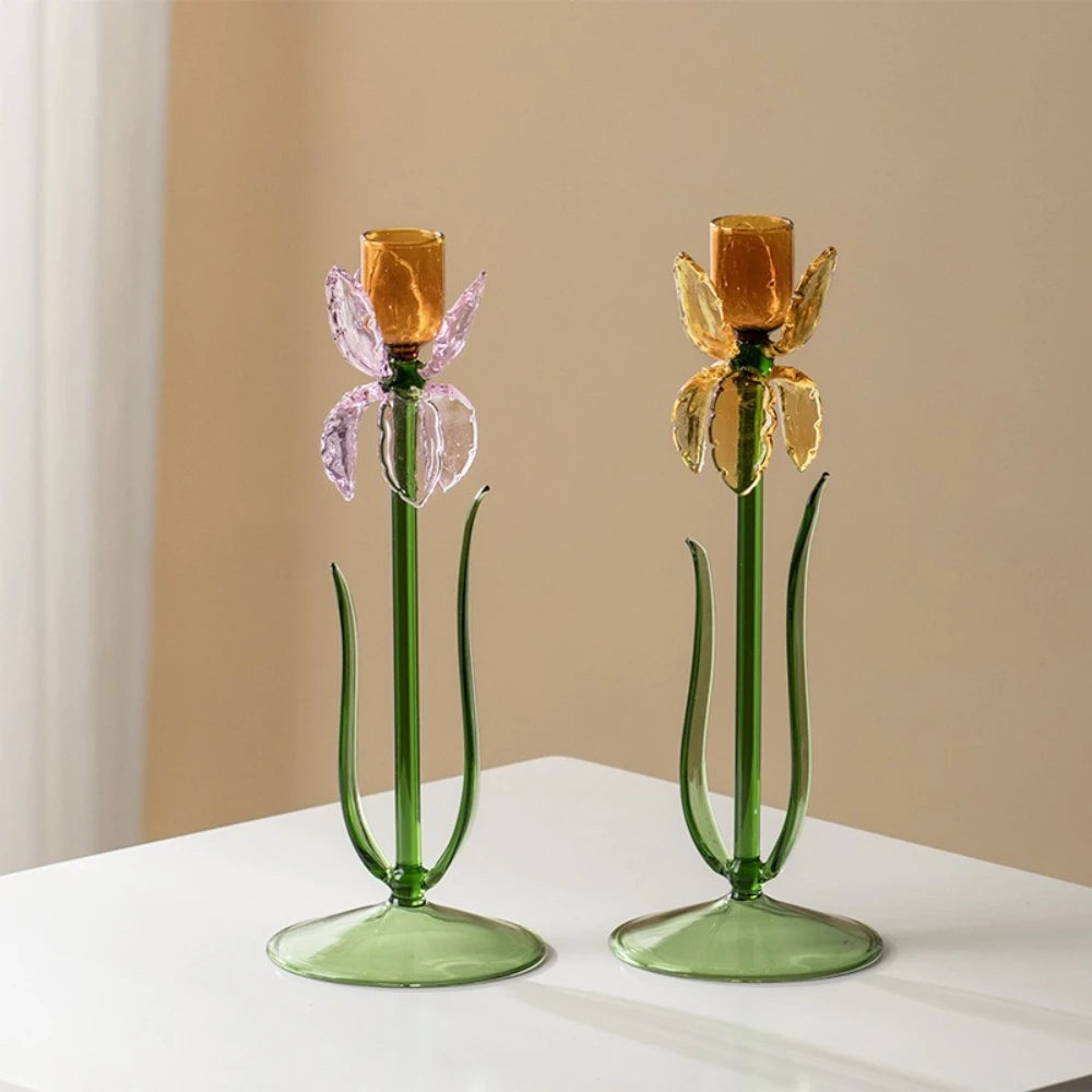 Pair of glass iris flower candle holders with green stems on white table