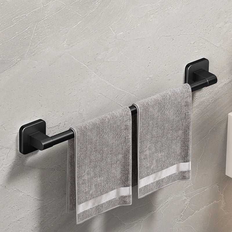 Single black towel bar holding two gray towels on a light wall surface