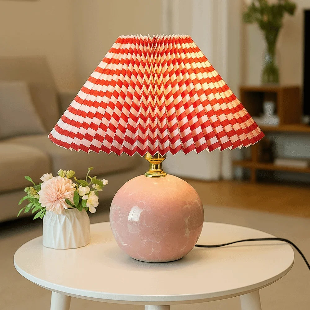 Red checkered pleated lampshade on a pink spherical table lamp in a living room