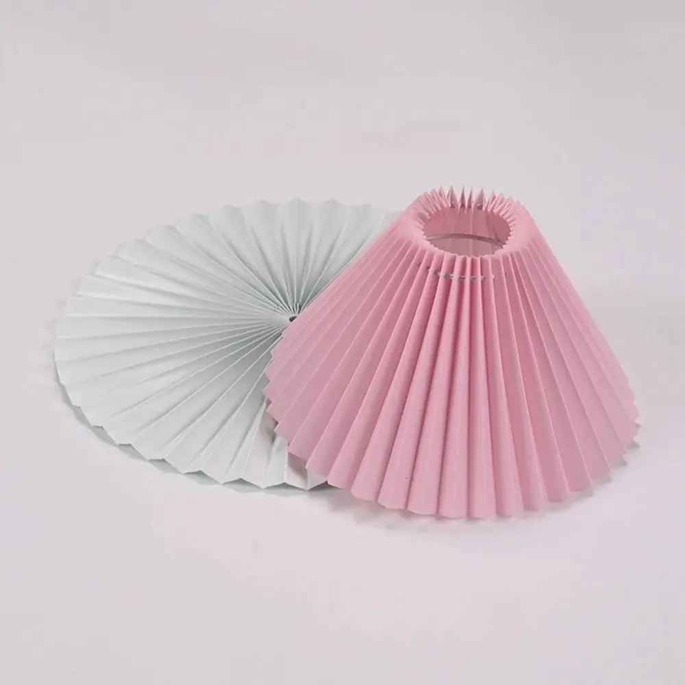 Pink pleated lampshade angled to show the inner plastic frame and fitting ring