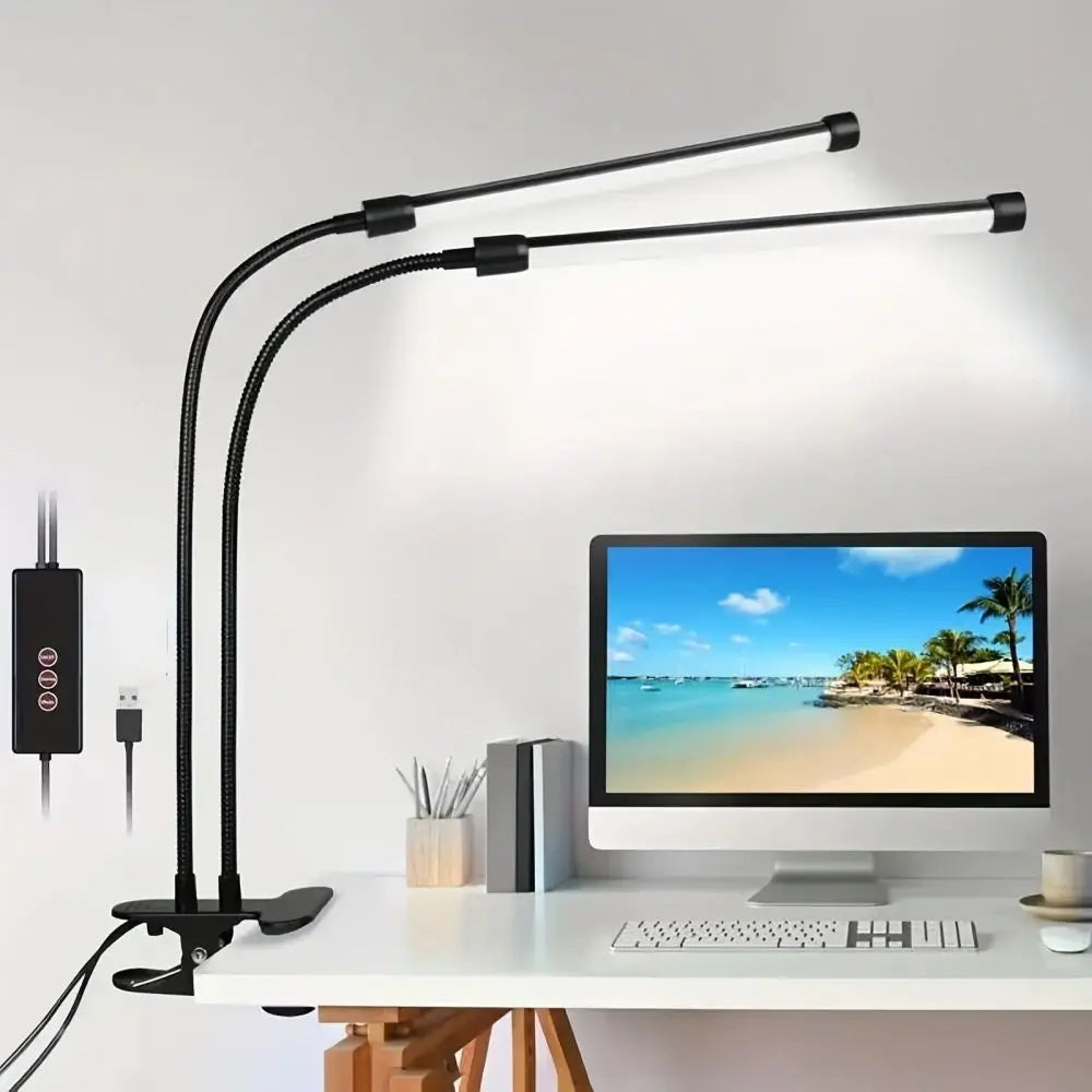 LED clip-on desk lamp with two flexible goosenecks lighting up a modern workspace with computer