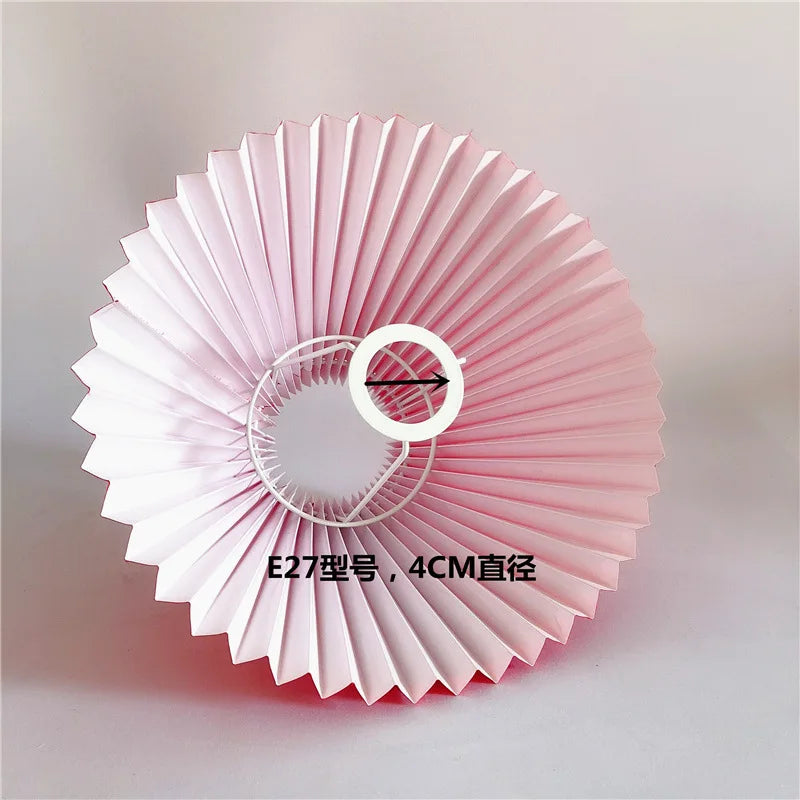 Pink pleated lampshade with visible E27 ring fitting, viewed from below