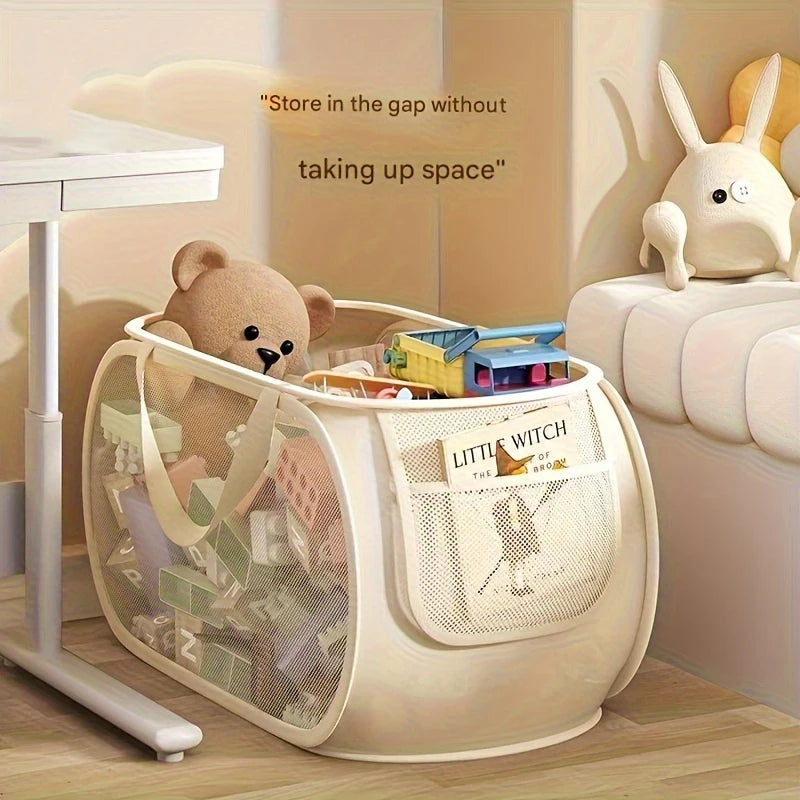Horizontal mesh toy storage basket under a desk, holding toys and books, beside a plush rabbit on a sofa