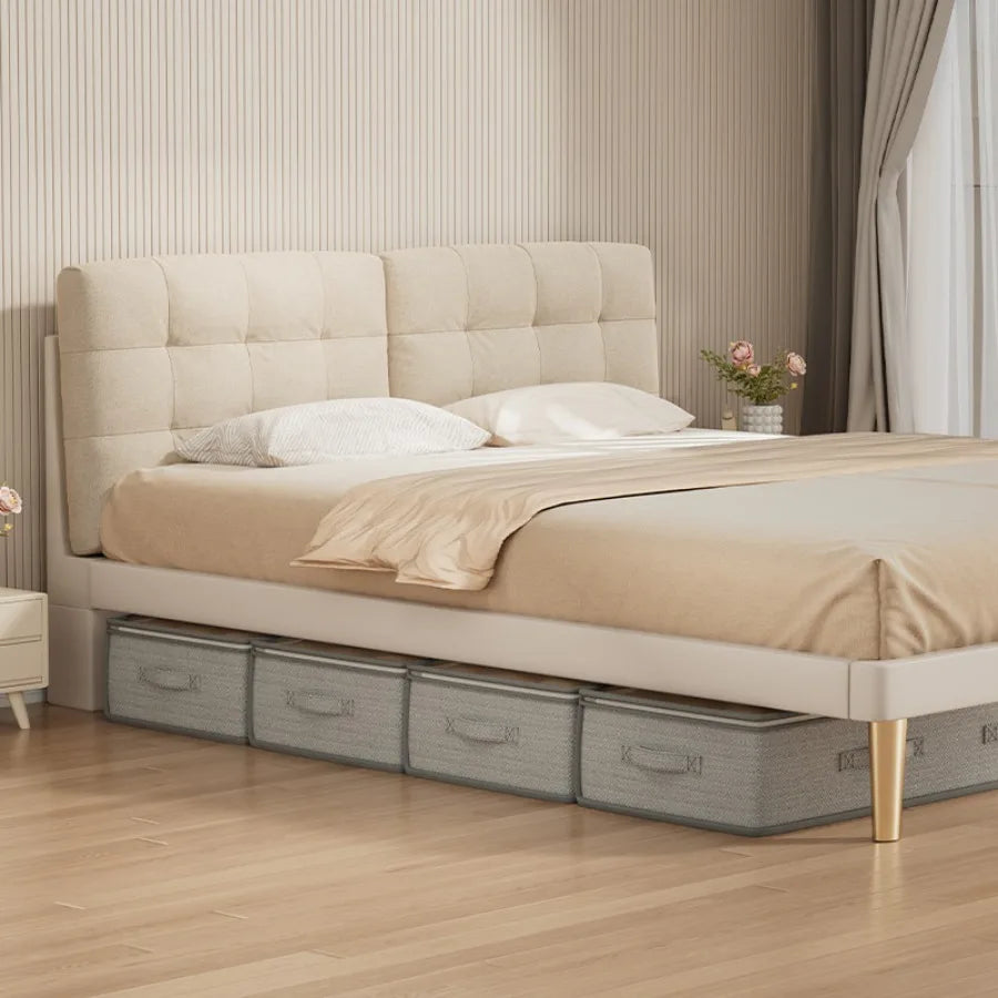 Four matching light green under-bed storage bins lined up under a beige upholstered bed in a tidy modern bedroom