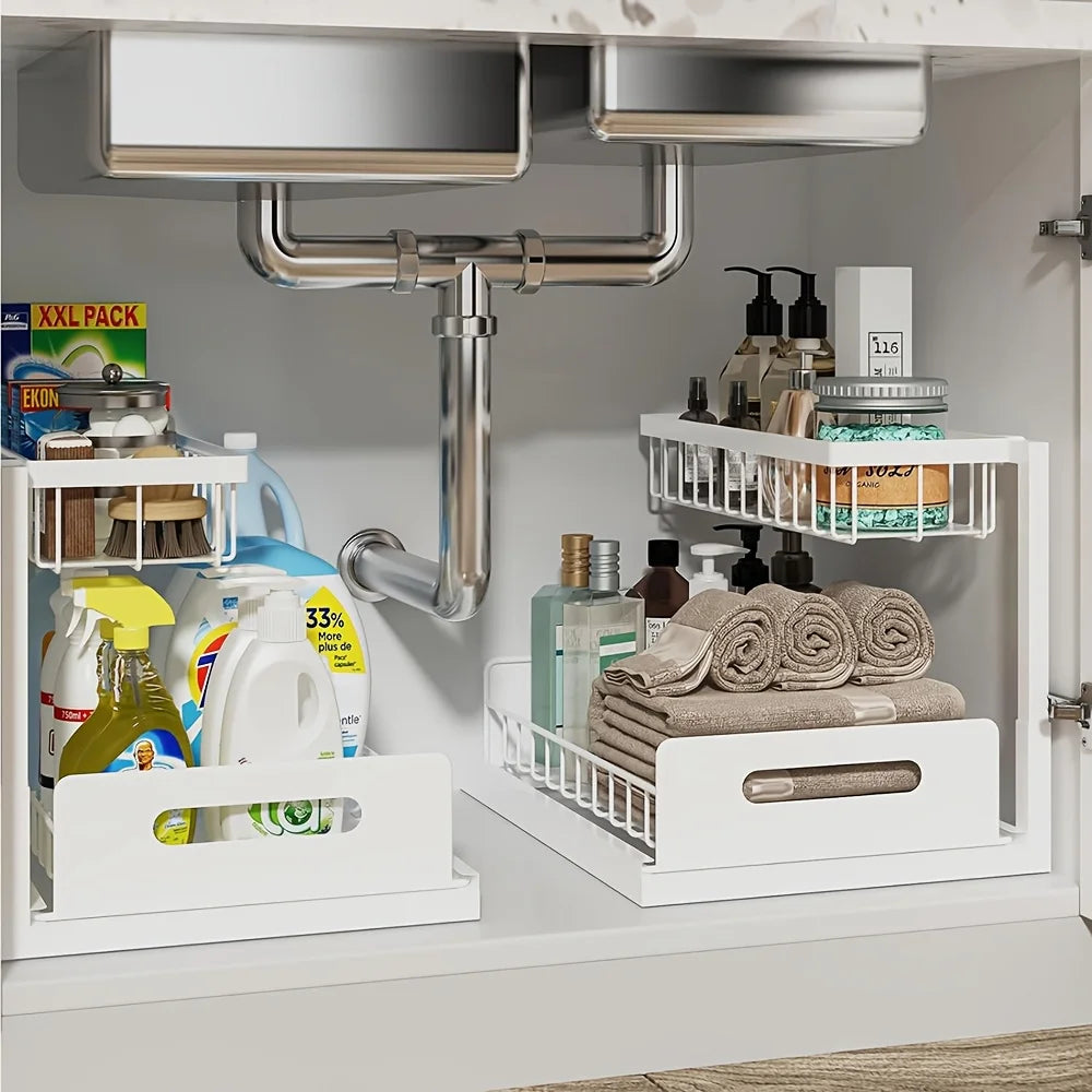 White 2-tier sliding metal organizer under a kitchen sink holding cleaning supplies and towels