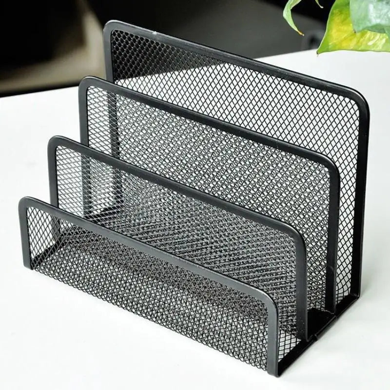 Close-up of black metal mesh mail organizer with three vertical slots on a light surface
