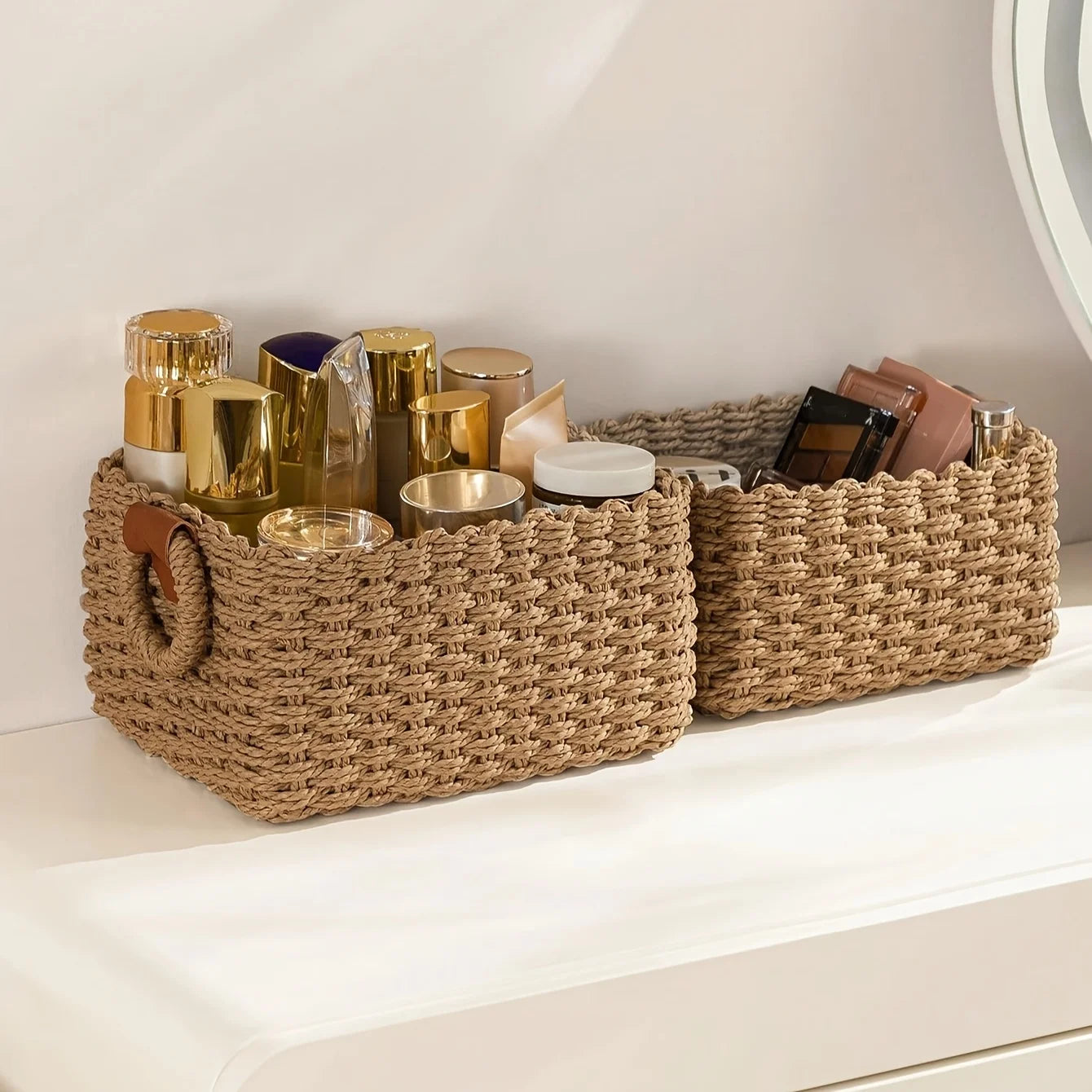 Woven paper rope storage baskets filled with cosmetics on a vanity