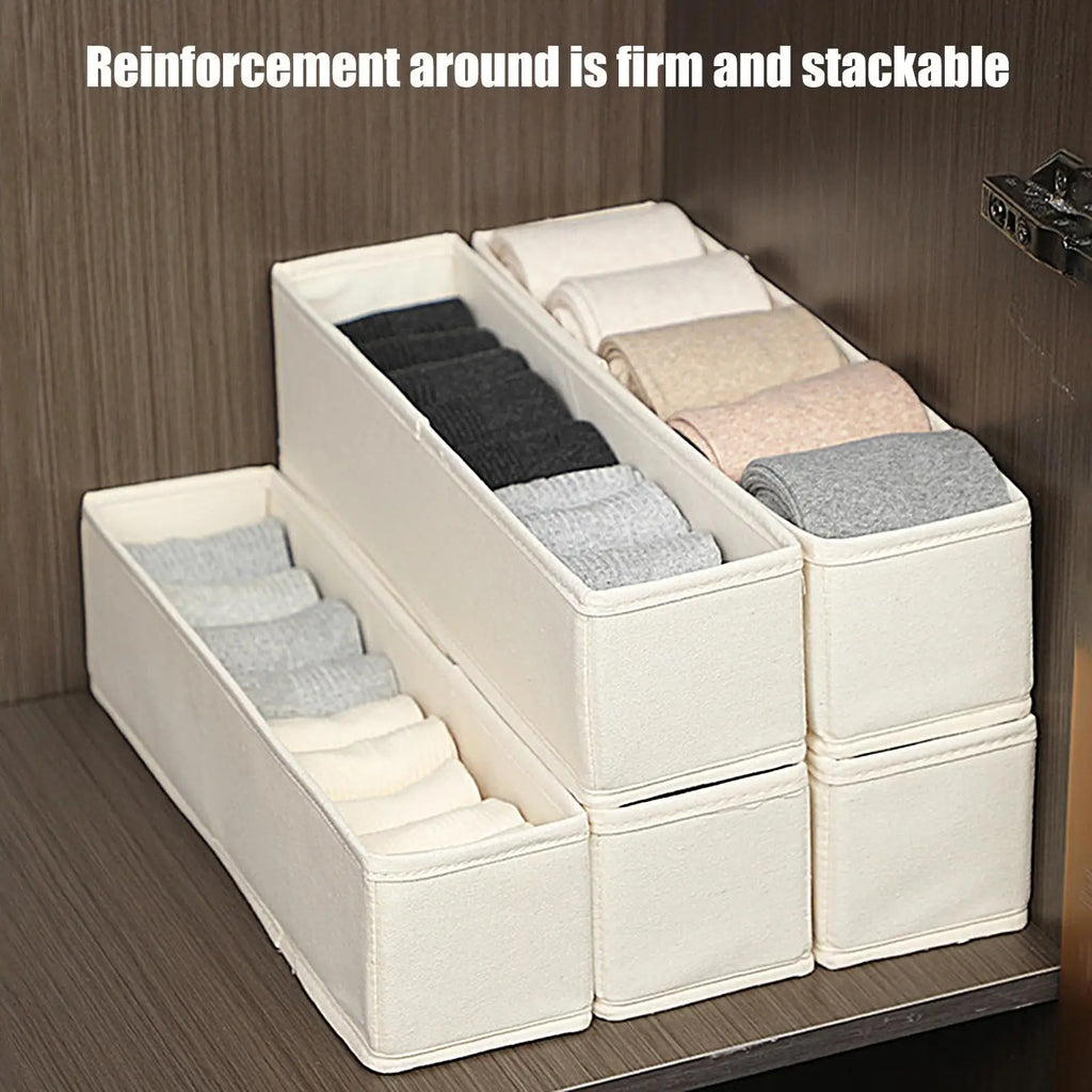 Slim beige fabric drawer organizer bins stacked and filled with neatly folded socks inside a wooden closet