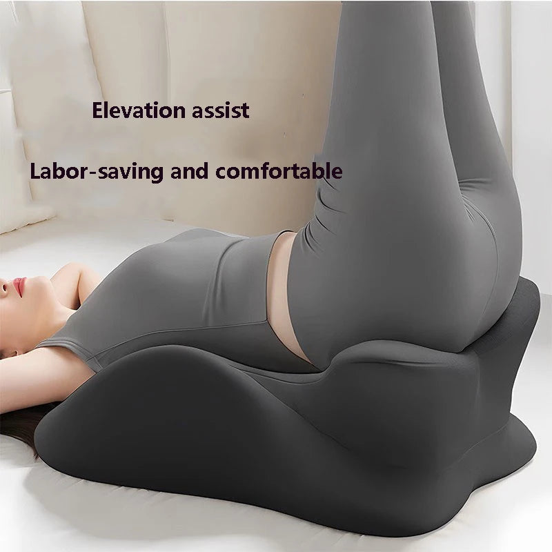 Black memory foam support wedge elevating legs while lying down, used for relaxation or gentle elevation