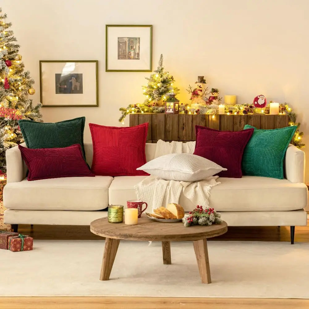 Large arrangement of corduroy striped pillow covers in red, green, and white on a spacious sofa in a holiday-themed living room