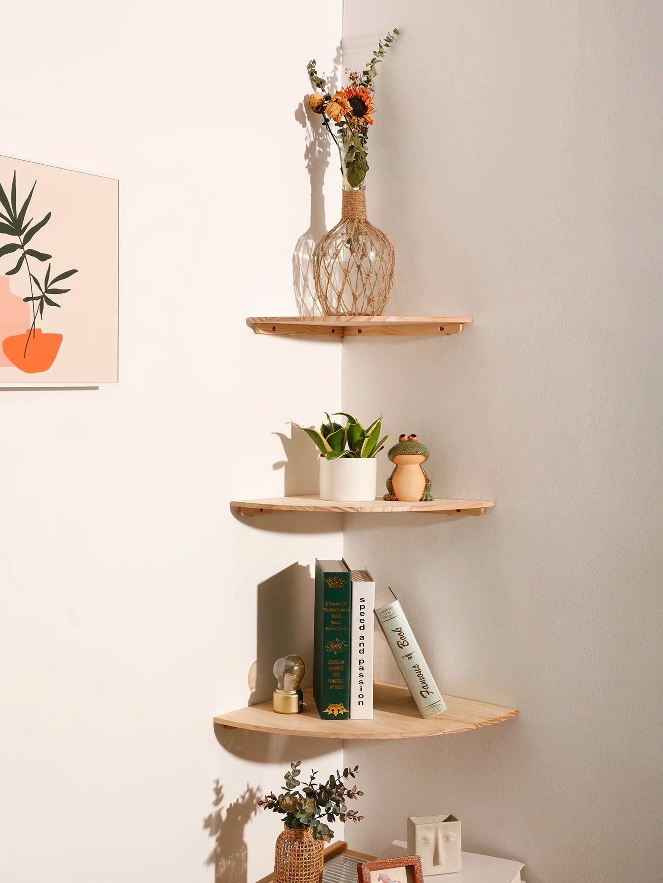 Three scalloped edge wooden corner wall shelves decorated with plants, books, and decor in a bright room
