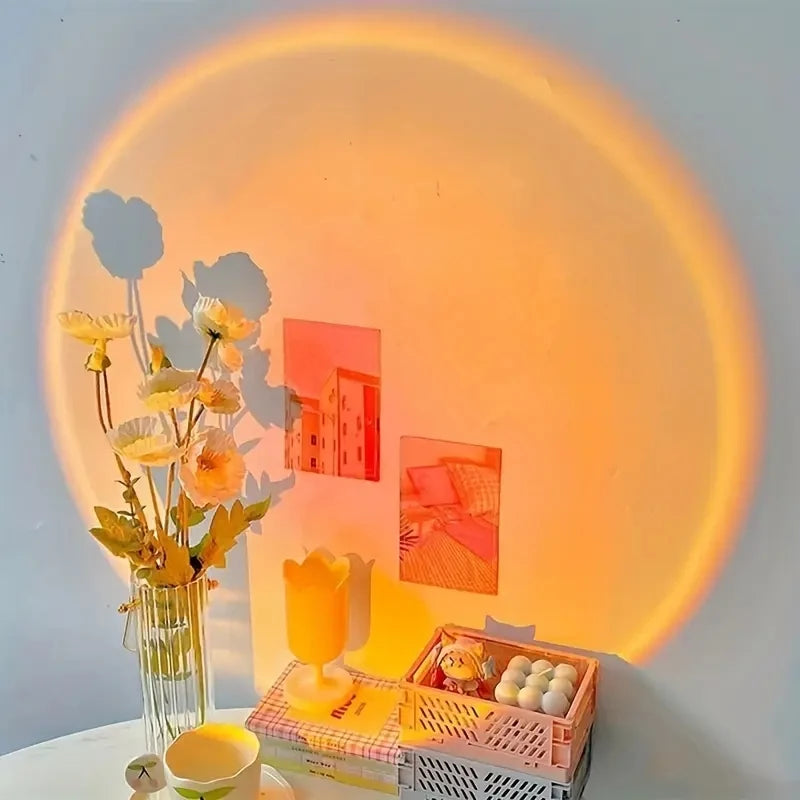sunset projection lamp illuminating a white wall behind flowers and art decor