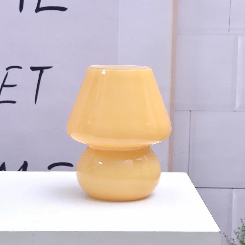 Yellow glass mushroom table lamp on a white surface